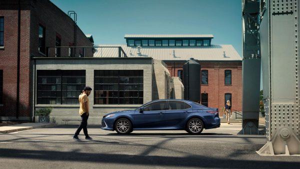 Man walking near a parked used Toyota vehicle