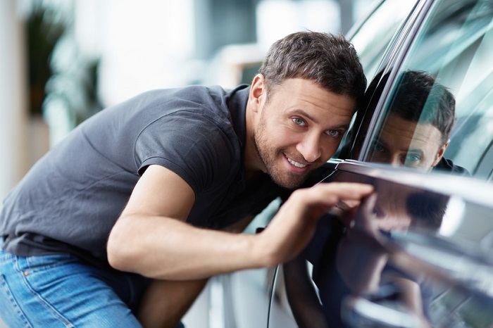 Person inspecting a used car for sale
